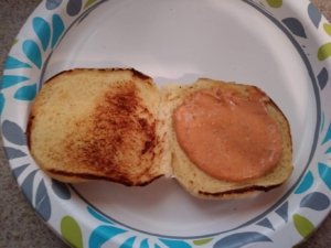 Spread harissa mayo on bun